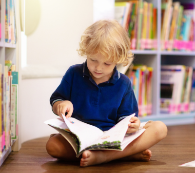 Small boy sitting on the floor reading a book