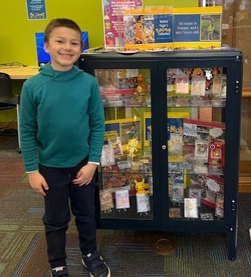 Young boy with Pokemon collection in a glass display case