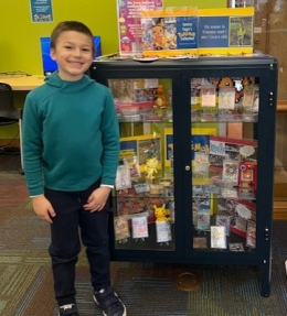 Young boy with Pokemon collection in a glass display case