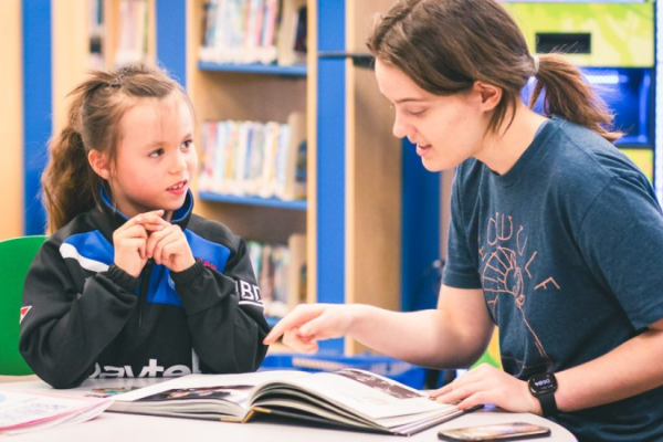 Teen and younger child reading
