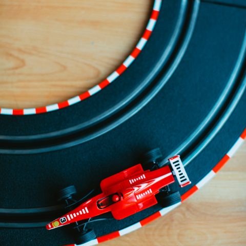 Black toy racetrack with red toy car.