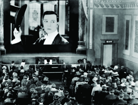 1920s movie theater with actor on screen in black and white