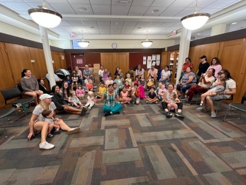 A group of people sitting on the floor smiling.