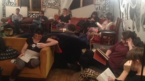 A photo of a silent reading party, with a room full of people reading.