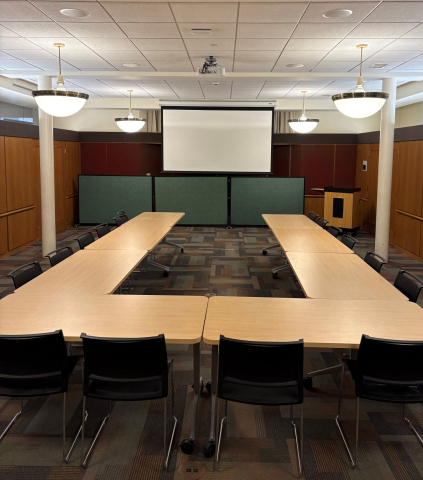 Meeting room with tables in a u-shape and screen