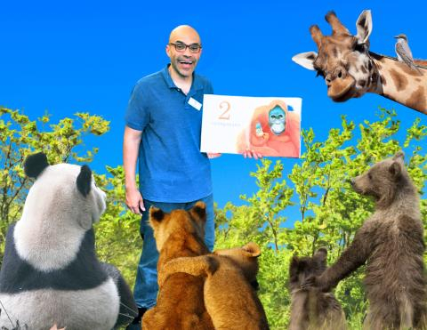 Photo of a man holding a book and animals facing him.