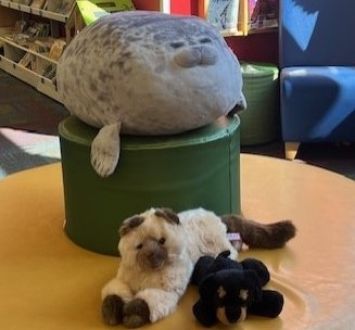 Photo of 3 stuffed animals, a seal, a cat, and a dog.
