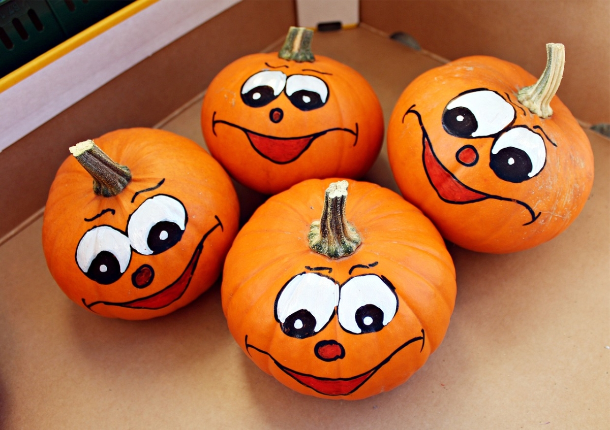 4 small pumpkins with faces drawn on.