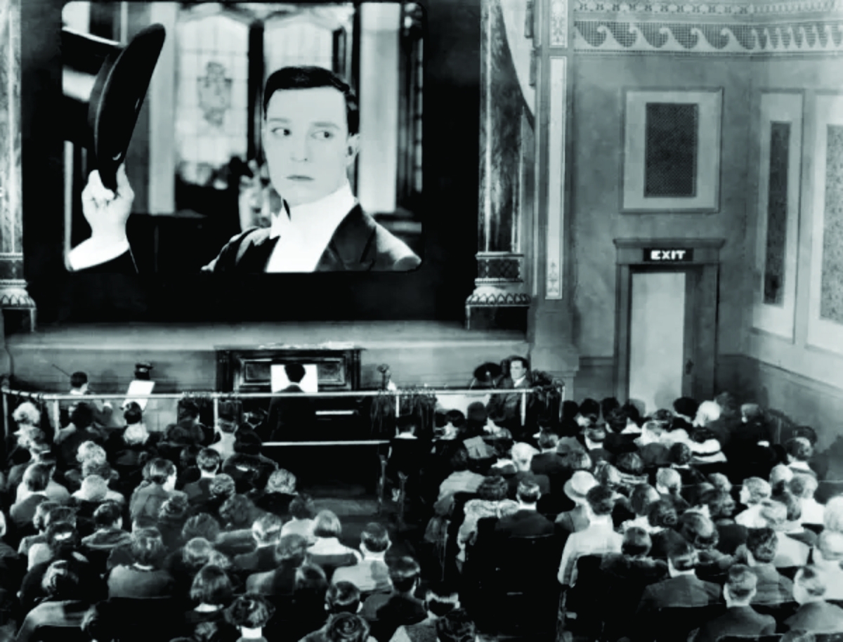 1920s movie theater with actor on screen in black and white