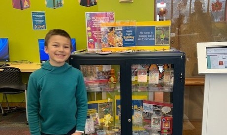 Young boy with Pokemon collection in a glass display case